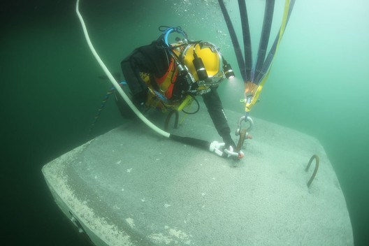March 2016: A diver connects a rope made of polyethylene of high molecular weight polyethylene (UHMWPE), covered with a protective layer of polyester with a breaking load of 20 metric tons, to one of the anchors on the lakebed to keep the docks instead. Image © Wolfgang Volz